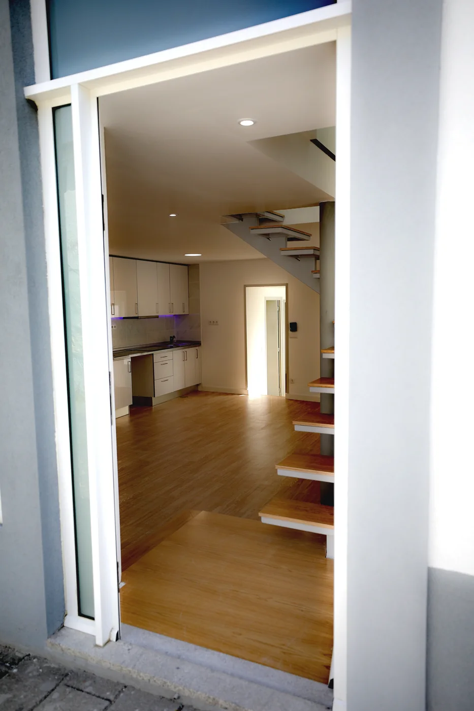 Vista da entrada para a cozinha integrada e a escada da Casa Campanhã